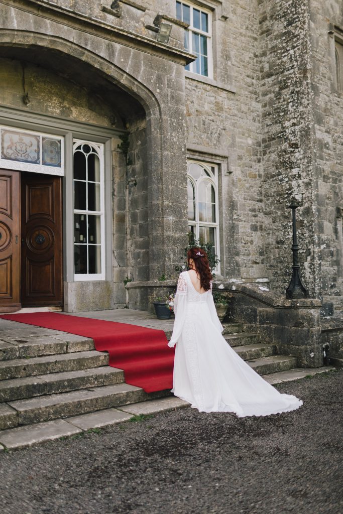 bride dressed in white dress heading towards the slane Castle with red carpet on the stairs for her civil wedding ceremony