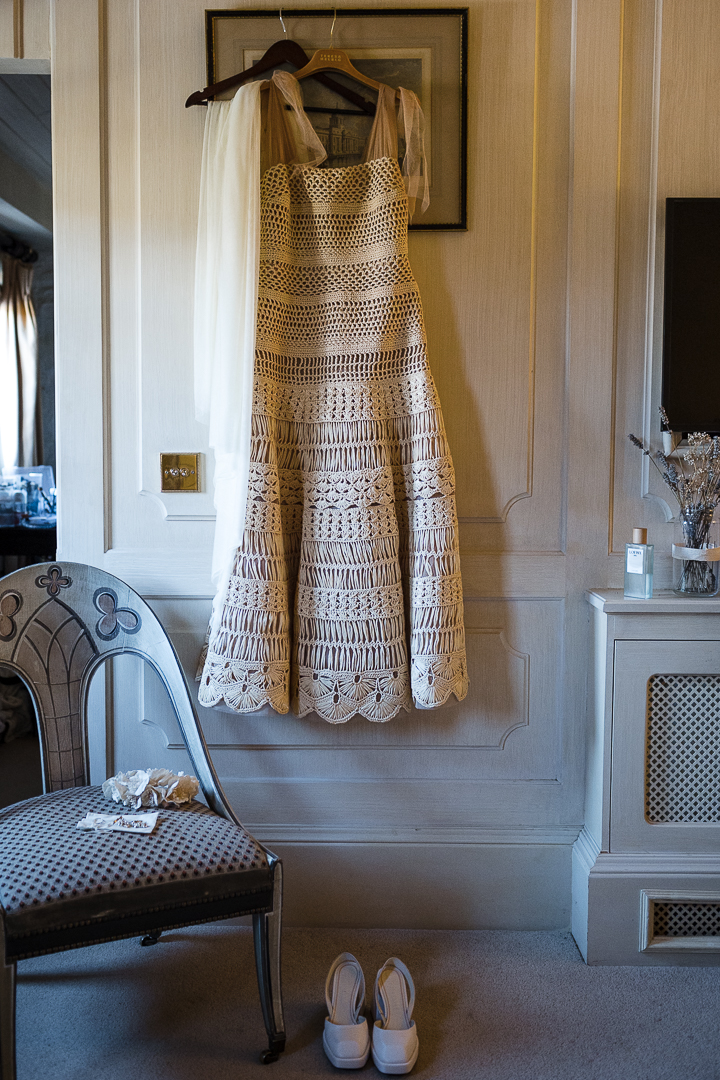 handknitted brides dress hanging on the door